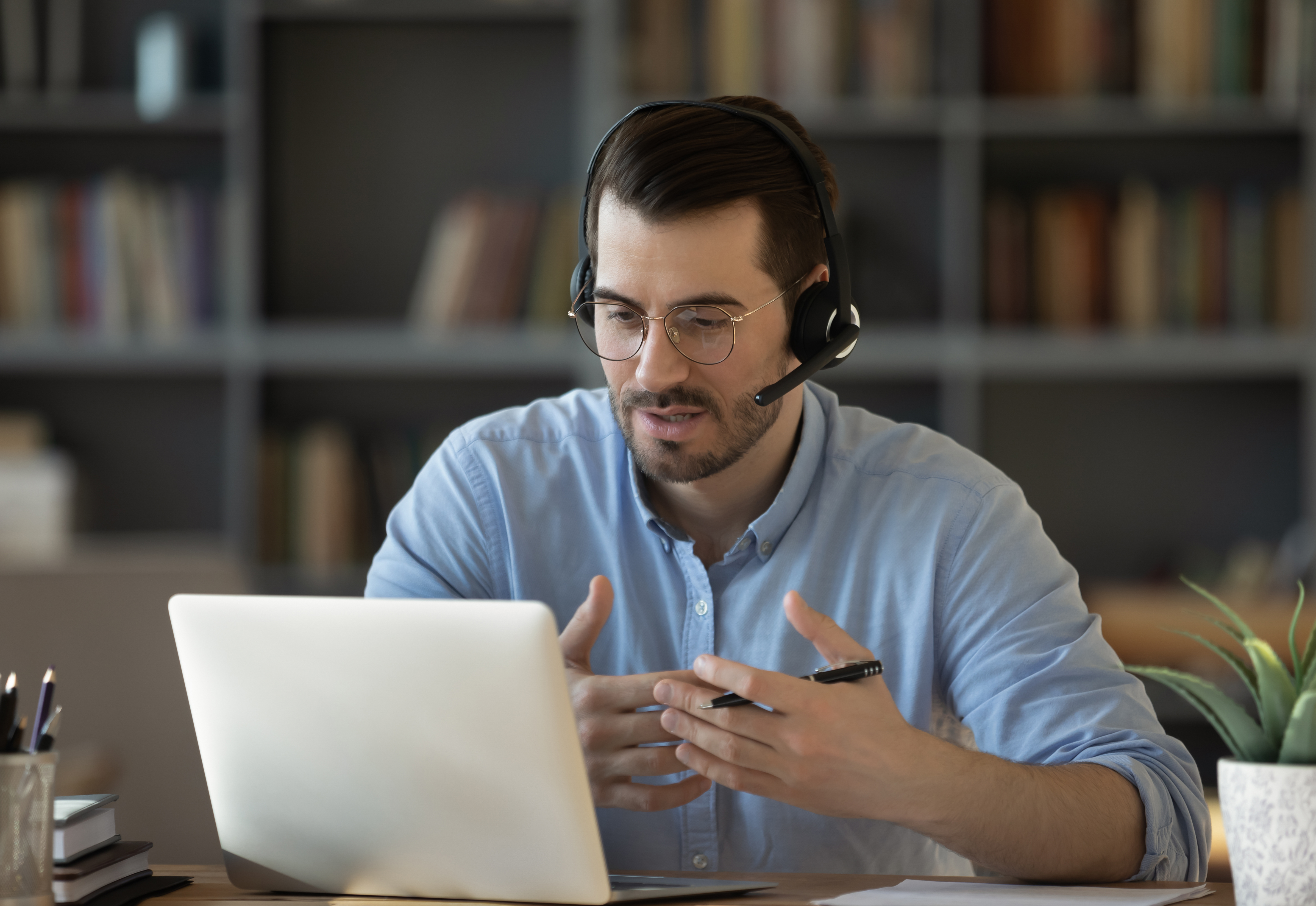 Confident,man,teacher,coach,wearing,headset,speaking,,holding,online,lesson,